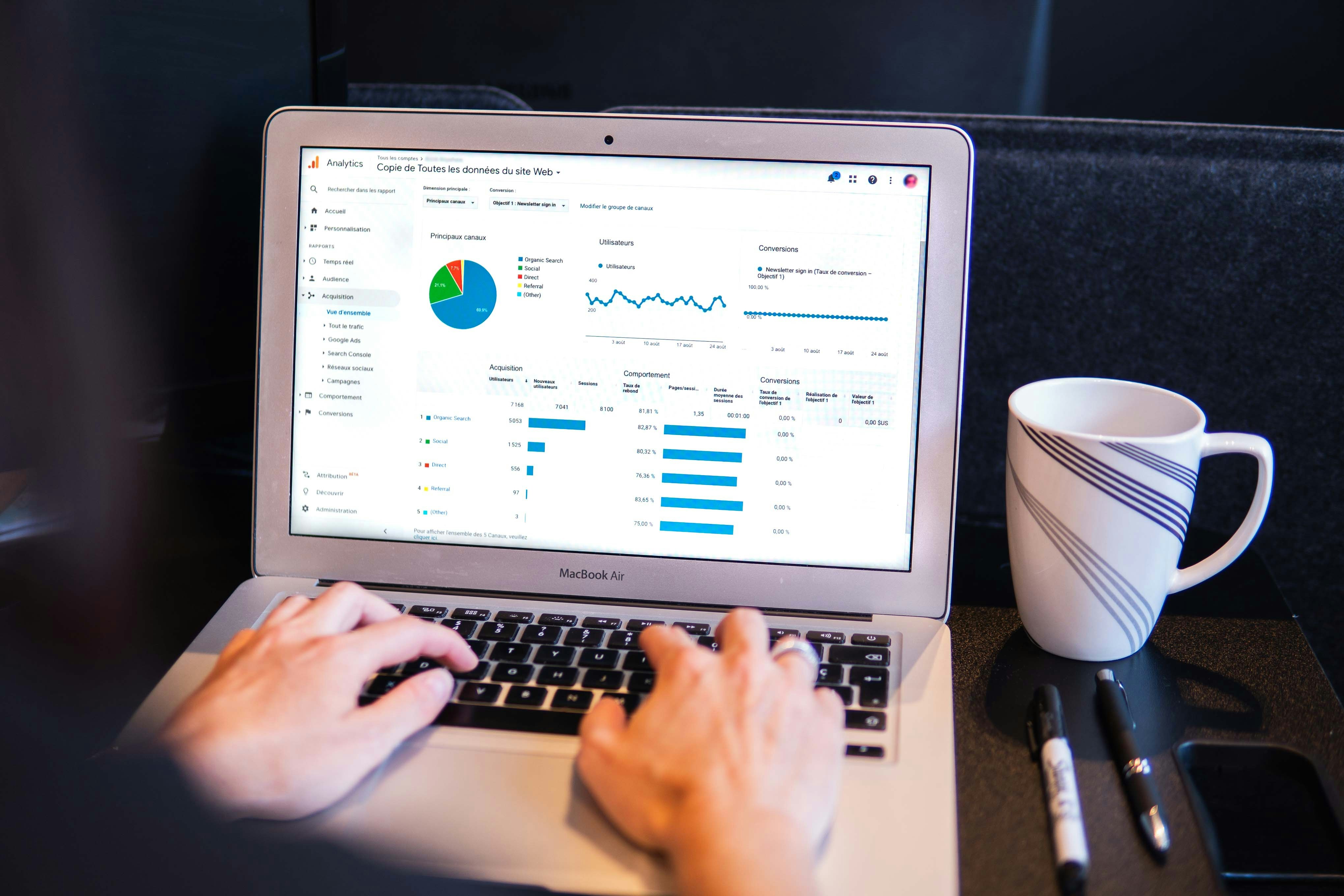 two hands typing a laptop with data analytics on screen